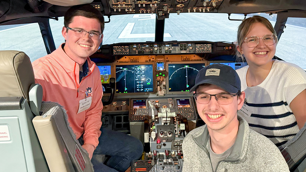 Auburn aerospace engineering students sit in the cockpit of a Boeing 737 aircraft simulator at the Delta Aircrew Training Center at Hartsfield-Jackson Atlanta International Airport.